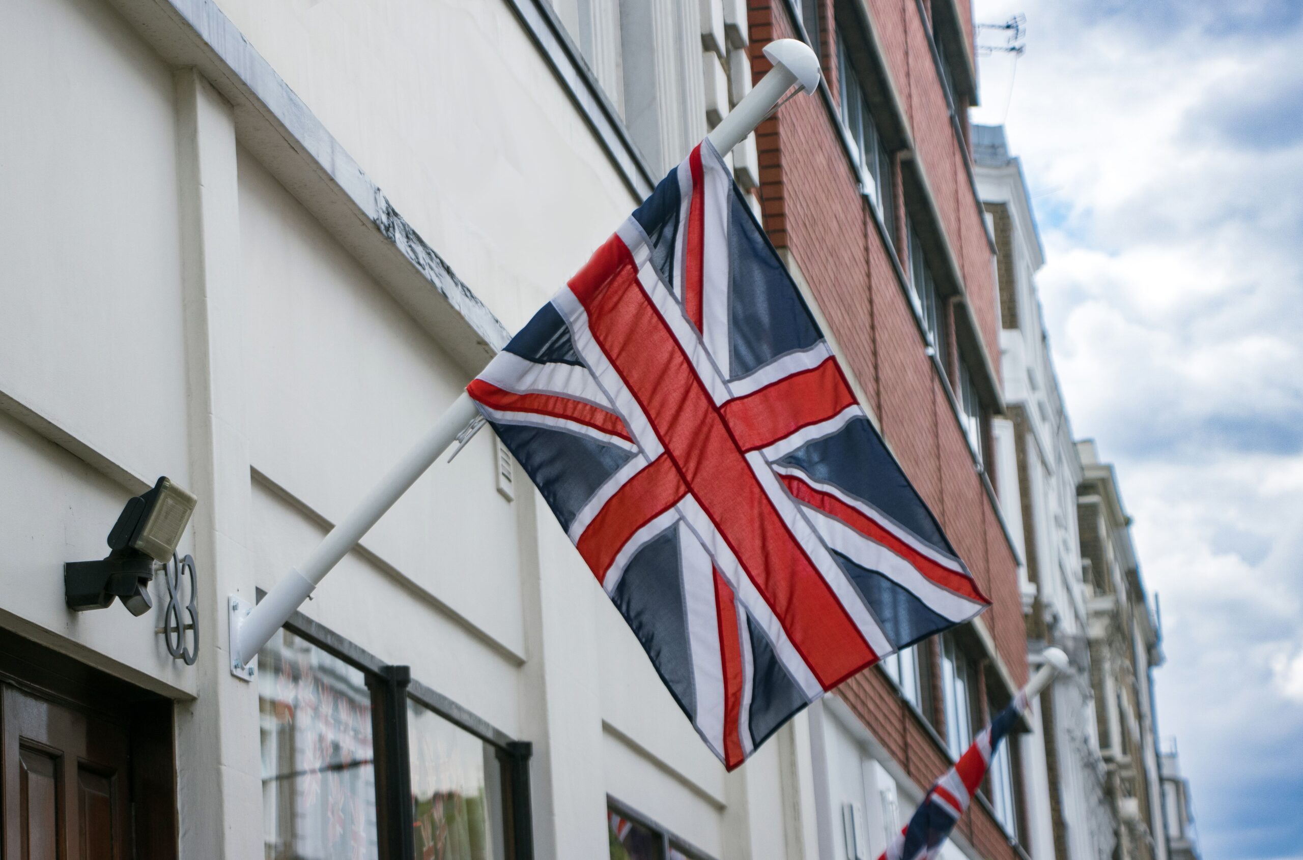 Union Jack flag mounted on a building in London street, England.